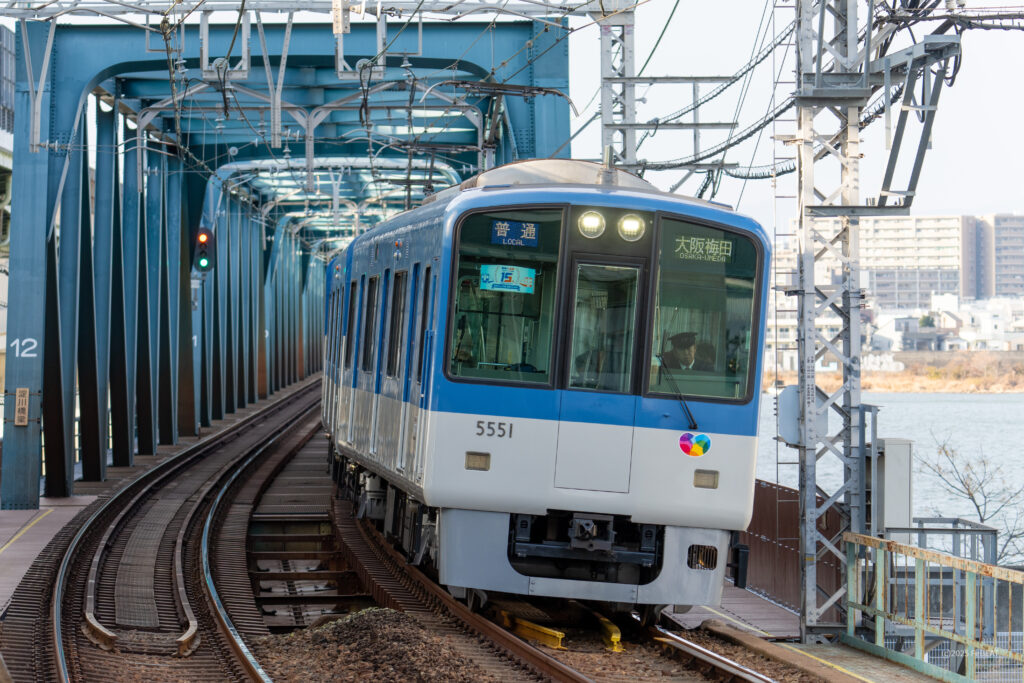 淀川橋梁を渡り阪神本線の淀川駅へと進入する5550系