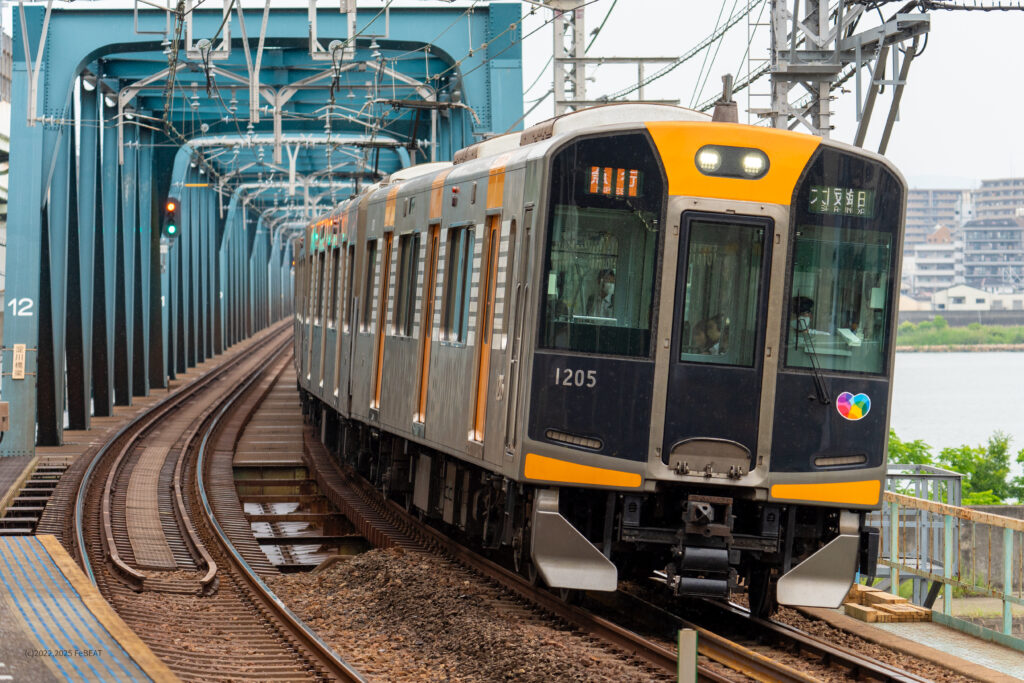 淀川橋梁を渡り阪神本線の淀川駅を通過する1000系