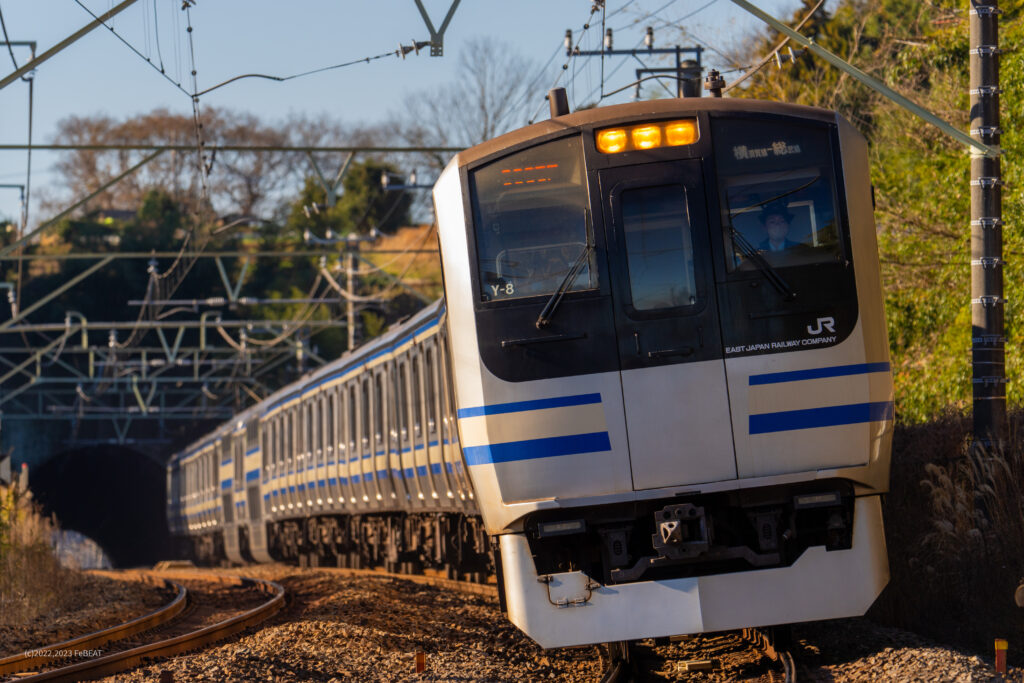 朝日が照らすなか総武本線を物井から佐倉へと走るE217系