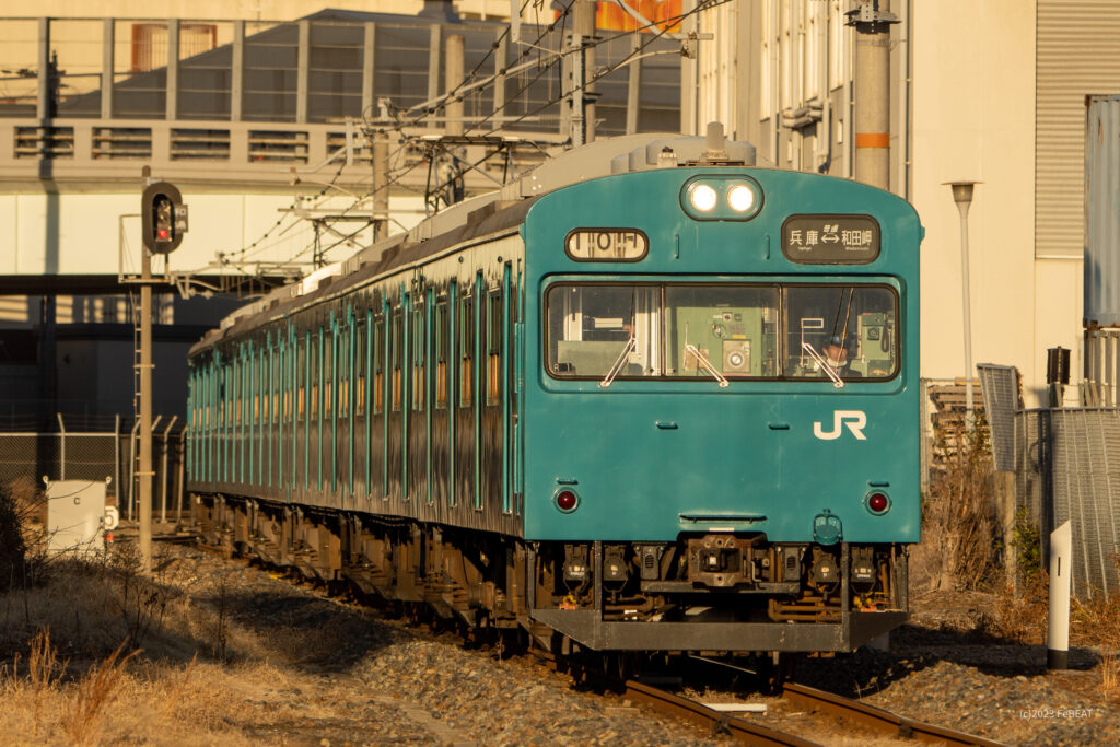 朝日を浴びて和田岬線を兵庫から和田岬へと走るスカイブルーの103系