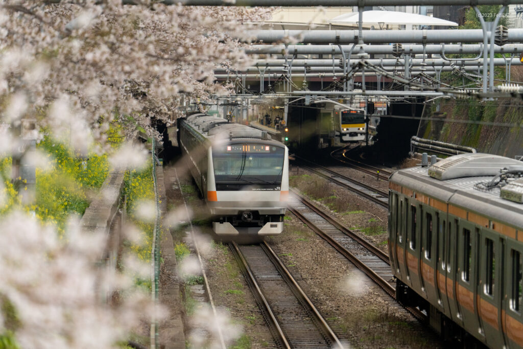 中央快速線の東中野駅近くで離合するE233系と、東中野駅に停車するE231系