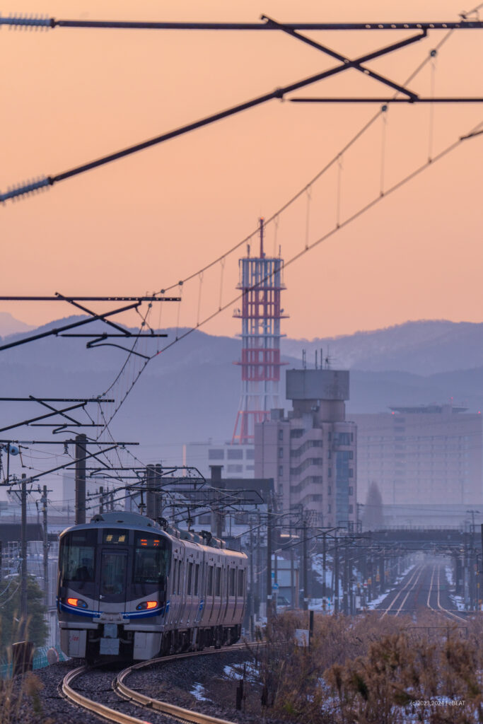 九頭竜川を渡り福井の街へと入る521系普通列車