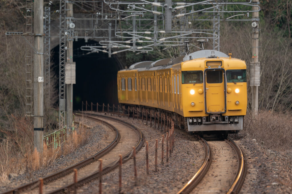 トンネルとカーブを抜けて伯備線の日羽駅へと進入する113系