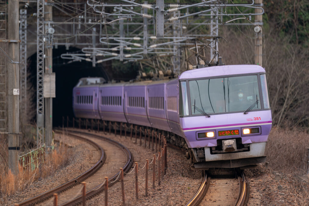 トンネルとカーブを抜けて伯備線の日羽駅へと進入する381系スーパーやくも色編成