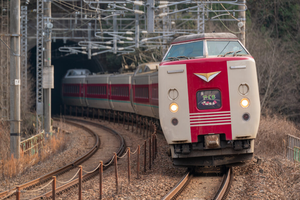 トンネルとカーブを抜けて伯備線の日羽駅へと進入する381系ゆったりやくも色編成