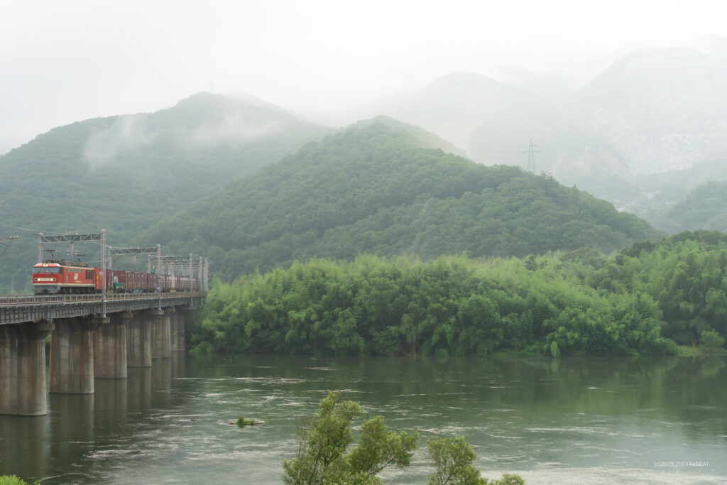 吉井川橋梁を渡り山陽本線を熊山から万富へと走るEF510形牽引コンテナ貨物列車